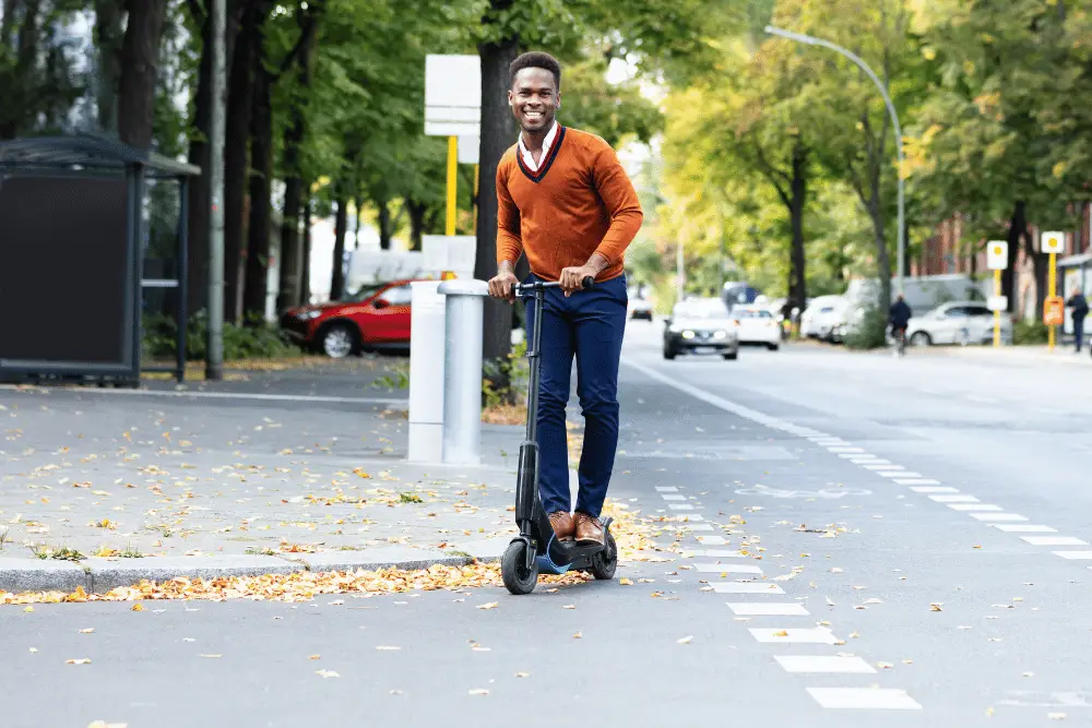 A black guy with smiley face riding an electric scooter