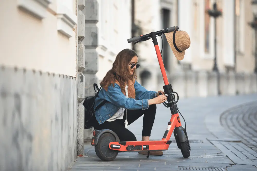 A stylish girl in blue denim jacket with an electric scooter