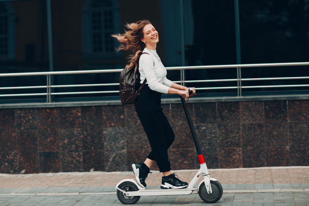 A girl with smile riding on electric scooter