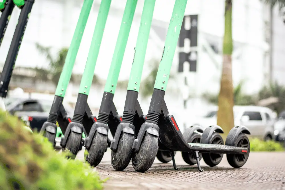 Light greenish electric scooters on a road side